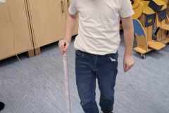 Przedszkolak-z-czarnymi-okularami-porusza-sie-po-sali-z-biala-laska.