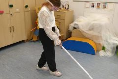 uczennica-z-zawiazanymi-oczami-porusza-sie-po-klasie-przy-pomocy-laski-scaled