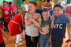 uczniowie-stoja-z-maskotka