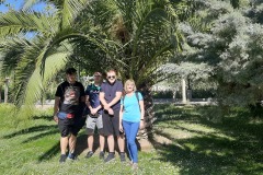 17.-Trzech-chlopcow-i-pani-stoi-pod-palma