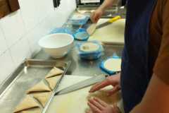 7.-Szymon-stoi-przy-stanowisku-pracy-i-lepoi-trojkatne-pierozki.