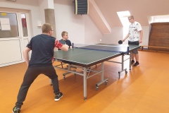 Dwoch-uczniow-trzyma-paletki-i-gra-w-tenisa-jeden-chlopak-sie-im-przyglada