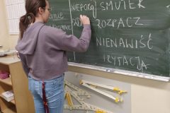 4.-Uczennica-zapisuje-hasla-o-emocjach-na-tablicy-scaled